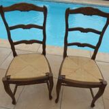 2 stylish solid wood chairs with high backs and straw seats