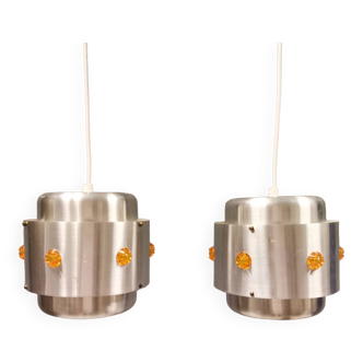 Two Space-Age hanging lamps, in silver-coloured aluminium with orange prisms.