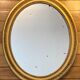 Oval mirror in carved wood, stuccoed and gilded with leaf Louis XVI style late nineteenth century