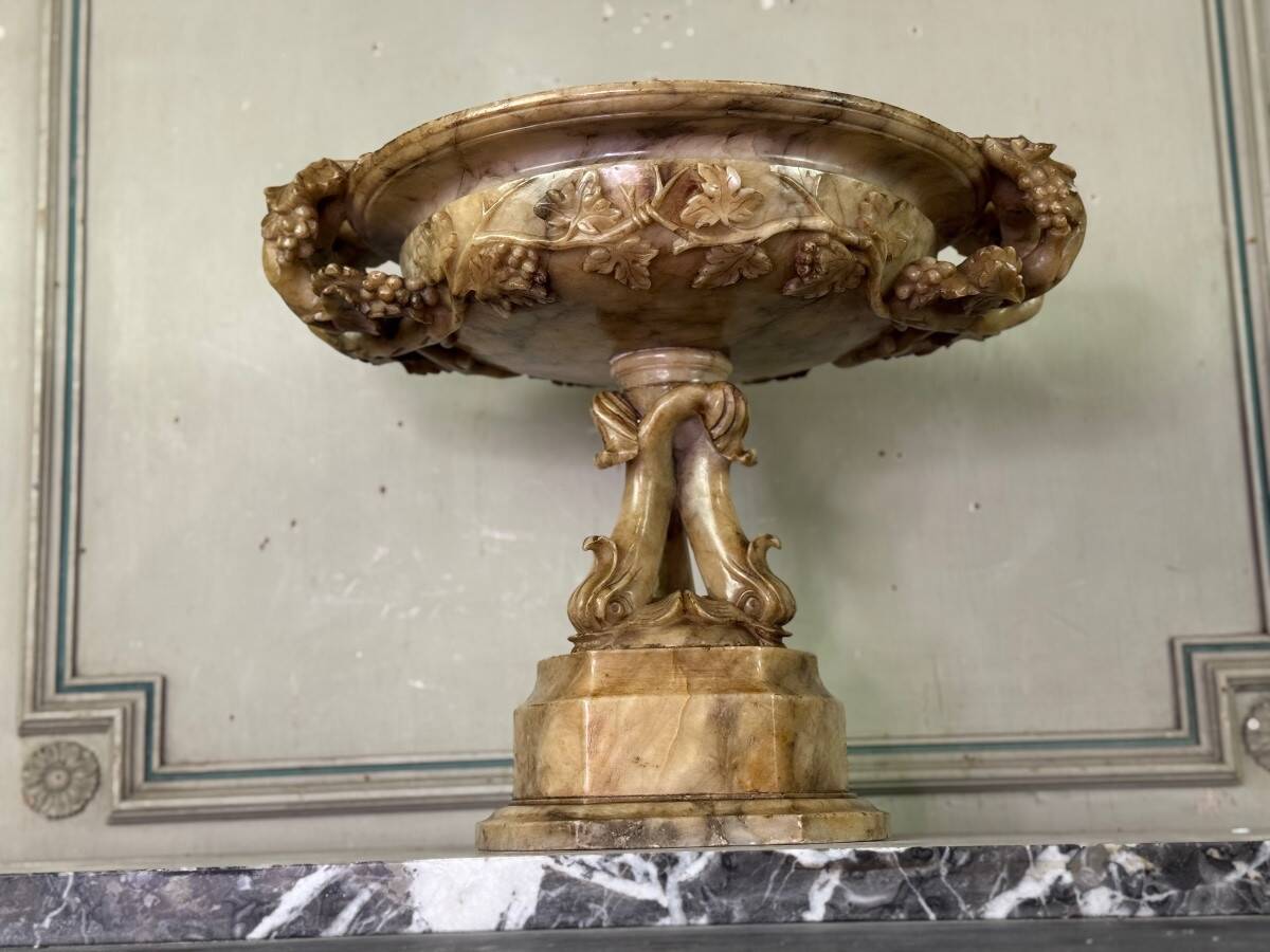 Alabaster bowl decorated with vine leaves on a base of three dolphins, circa 1880.