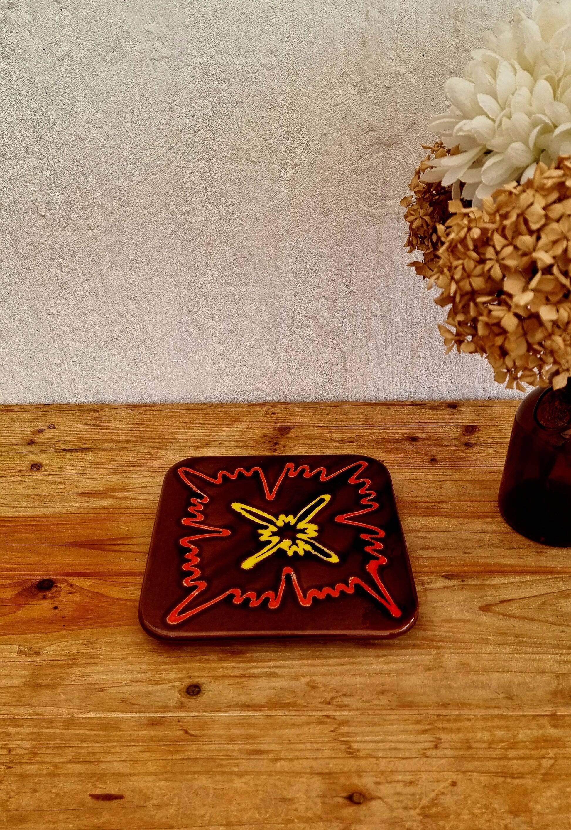 Vintage ceramic trivet with a 70s pattern.