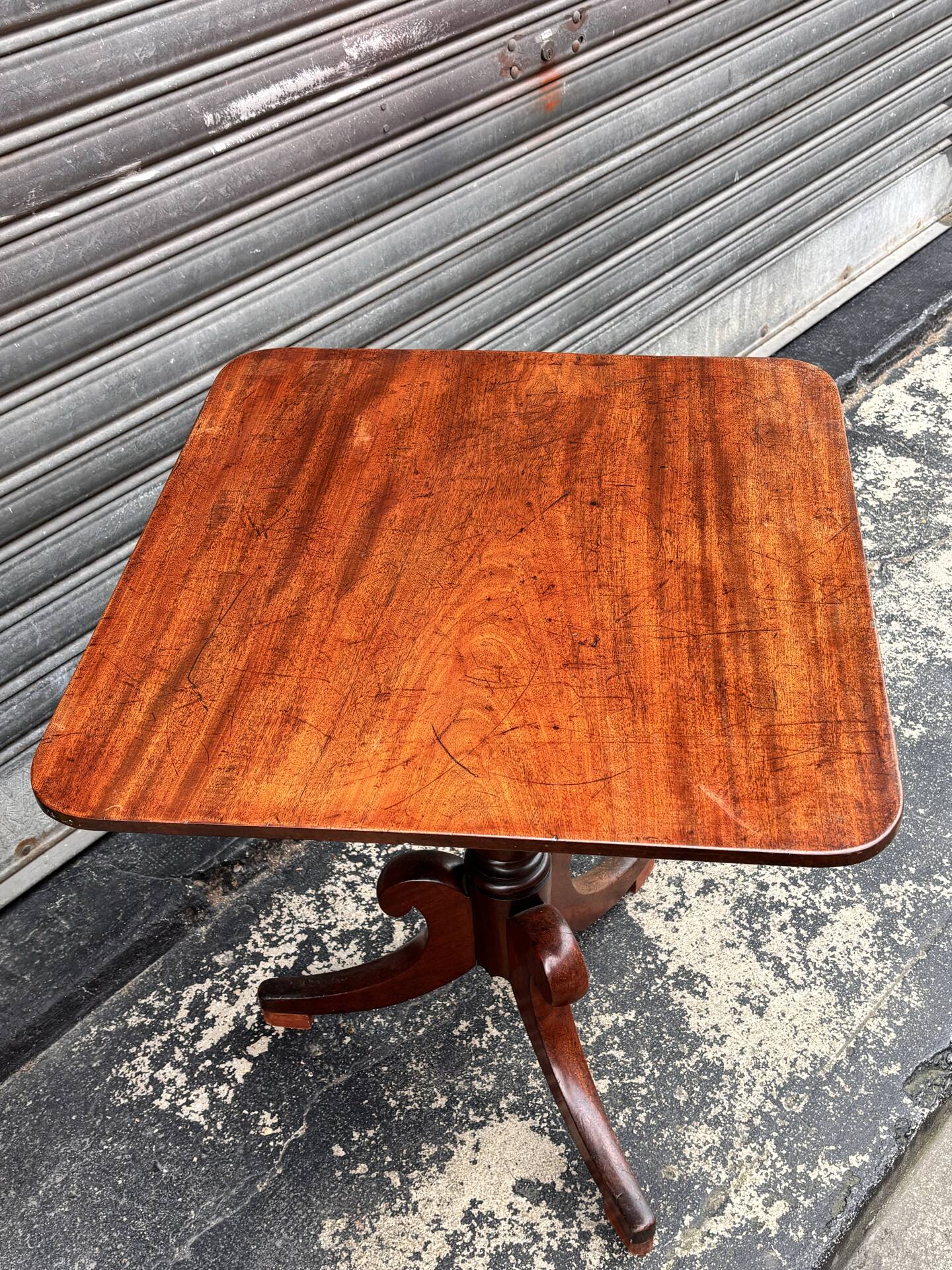 19th-century solid mahogany table with a tilting top and brass mechanism.