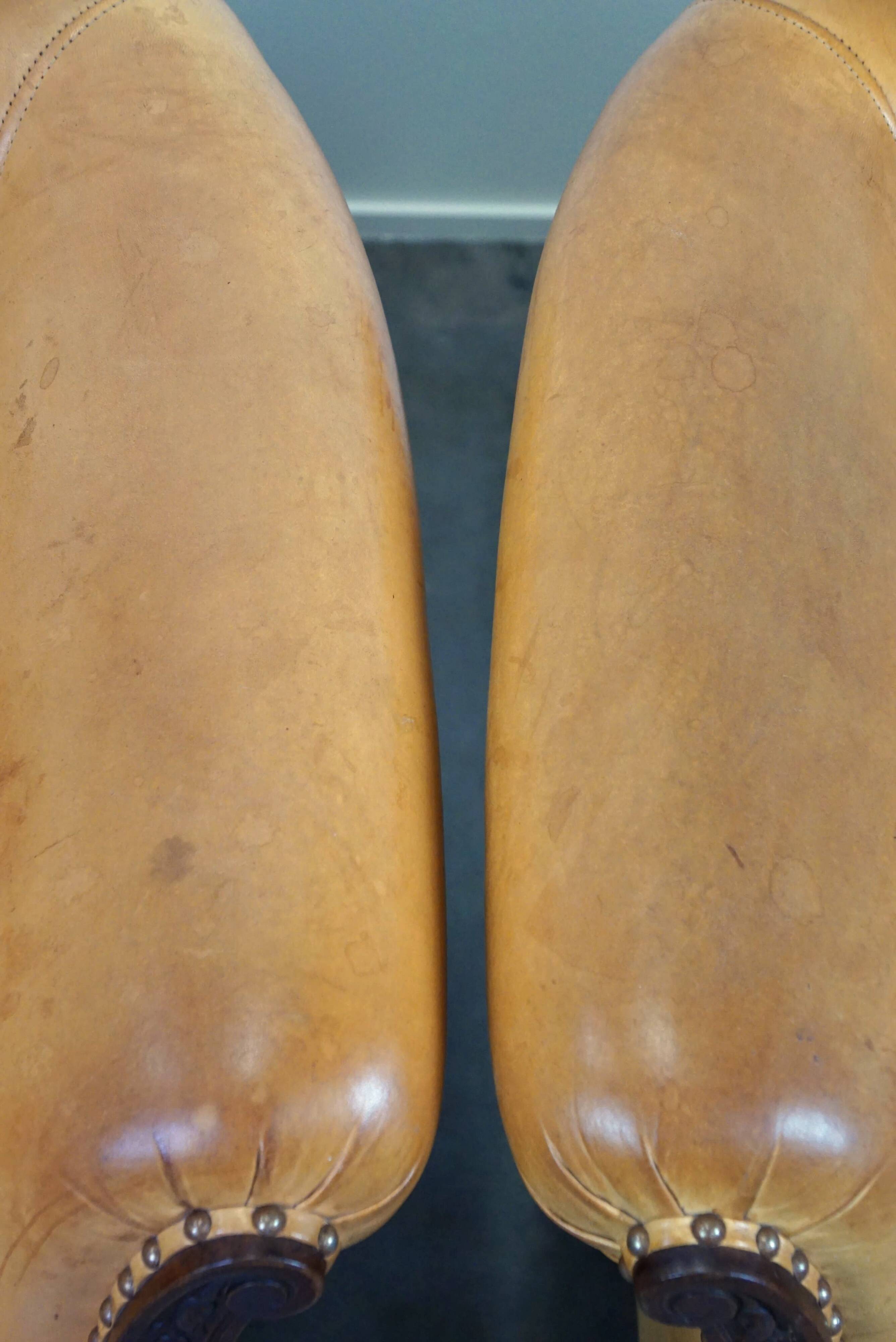 Unique old set of 2 club armchairs and a couch in cognac-colored leather with wheels