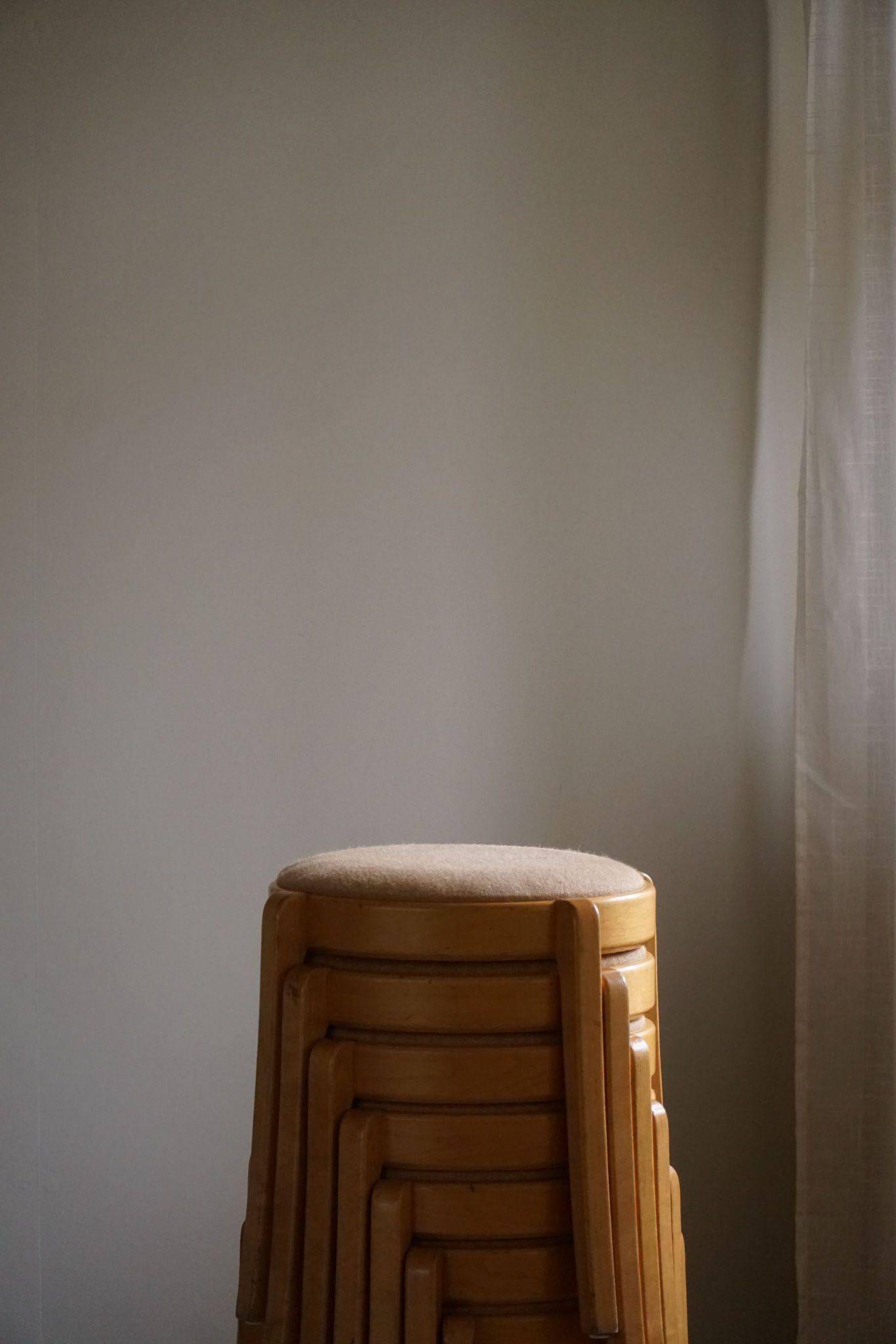 Modern Swedish, set of 14 stackable stools in birch and hessian fabric, 1980s.