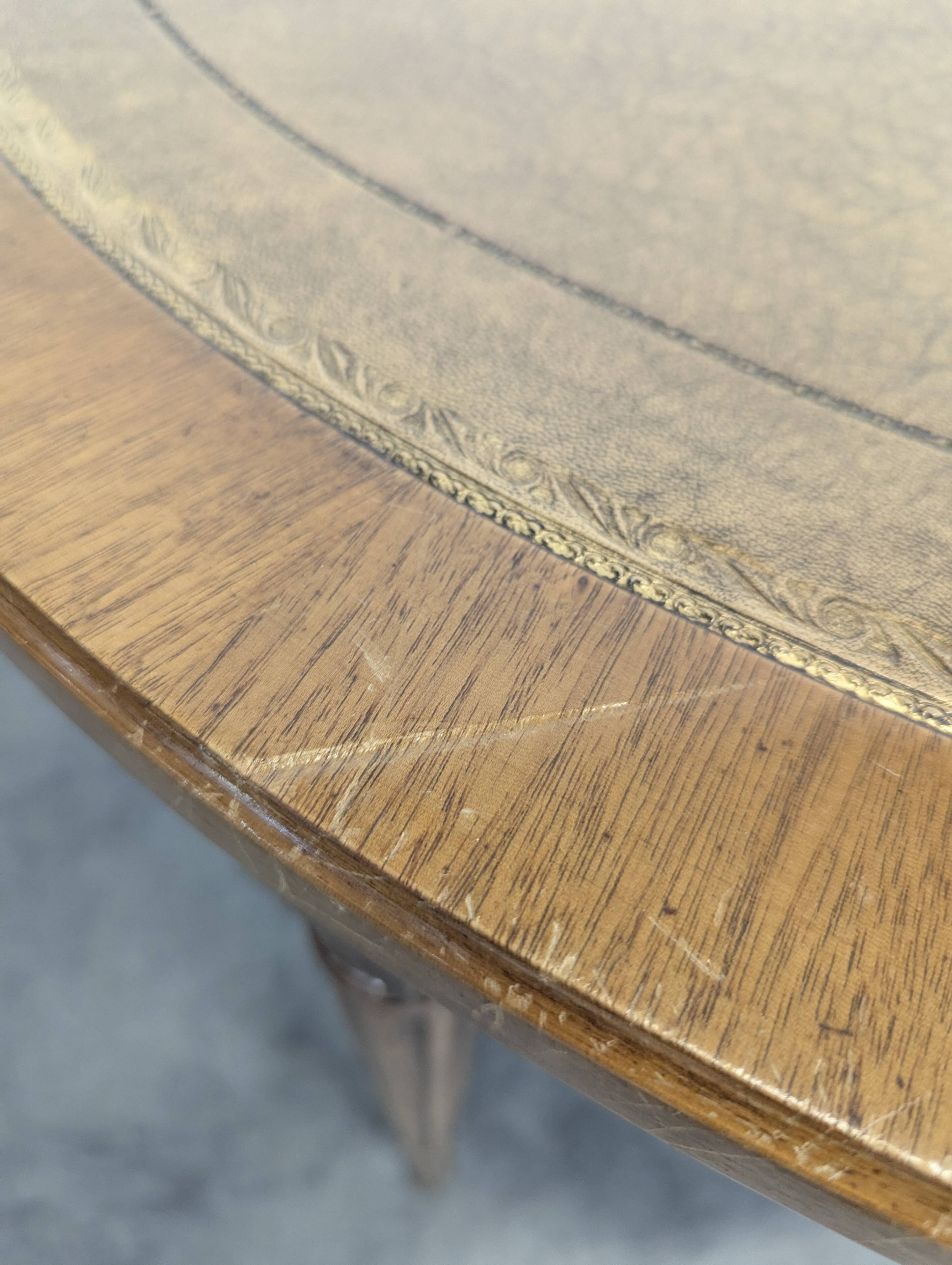 Louis XVI style dining table with a leather top.