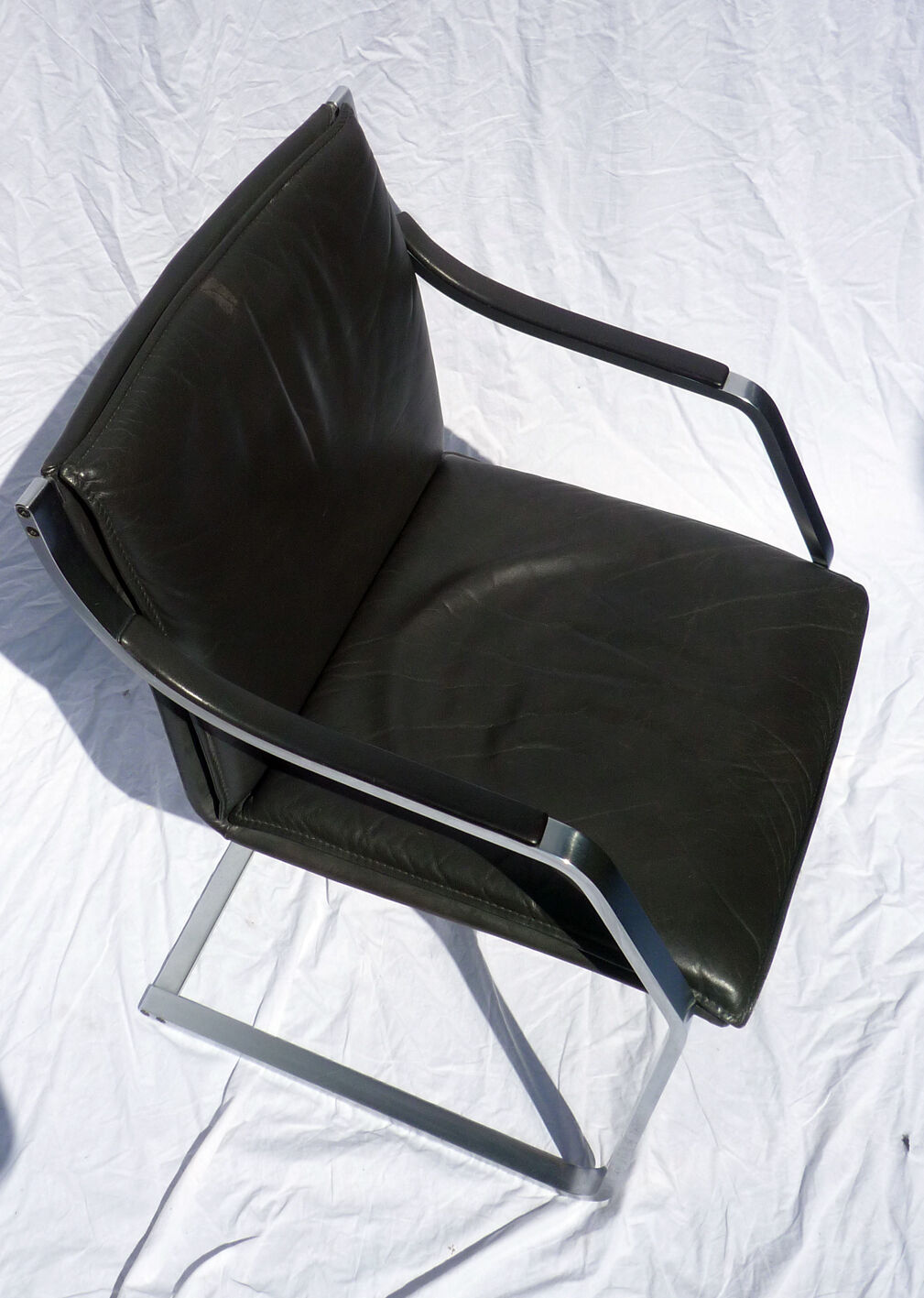 Chair with steel and leather armrests