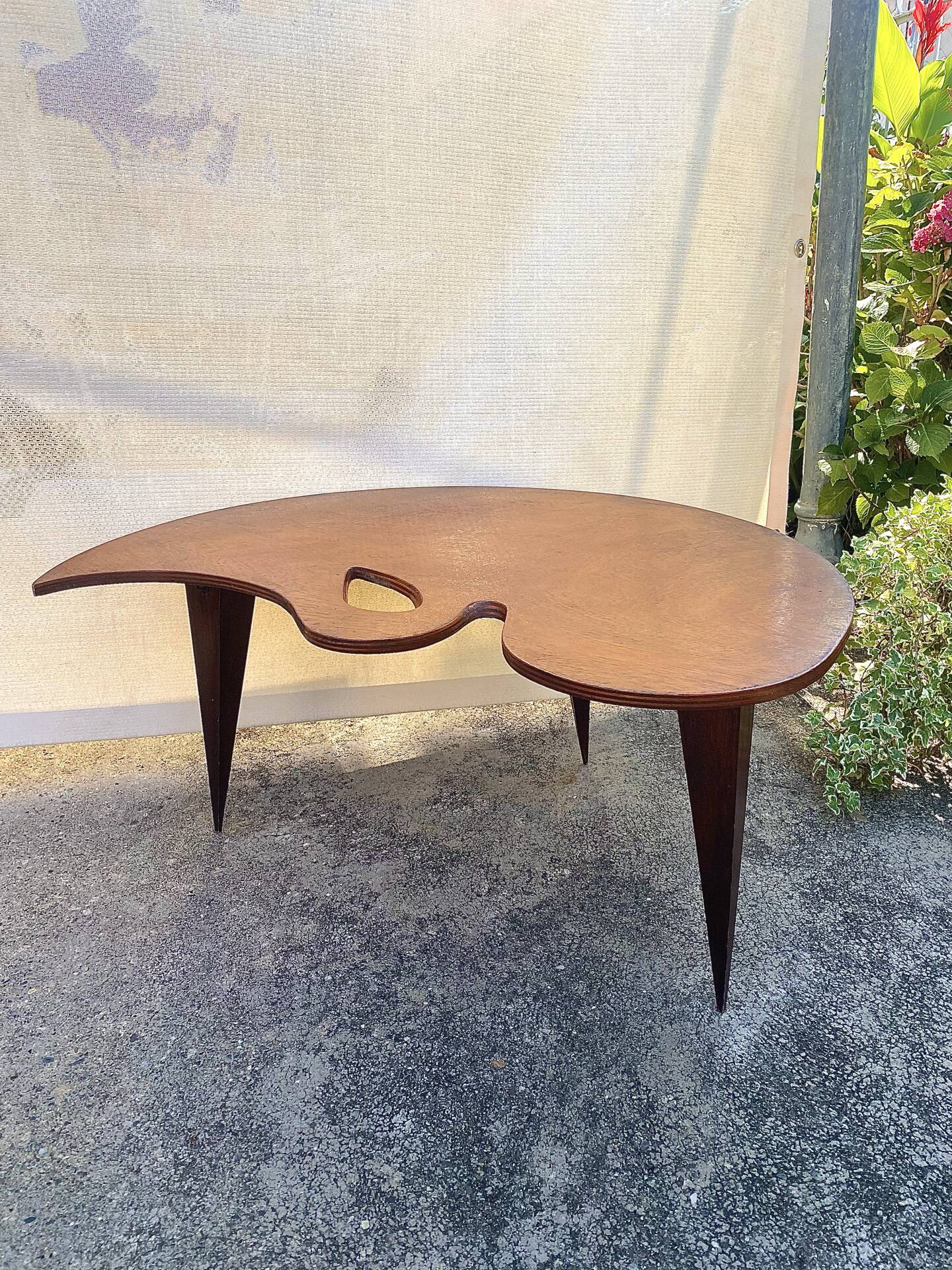 Mid-century coffee table with a palette shape and splayed legs.