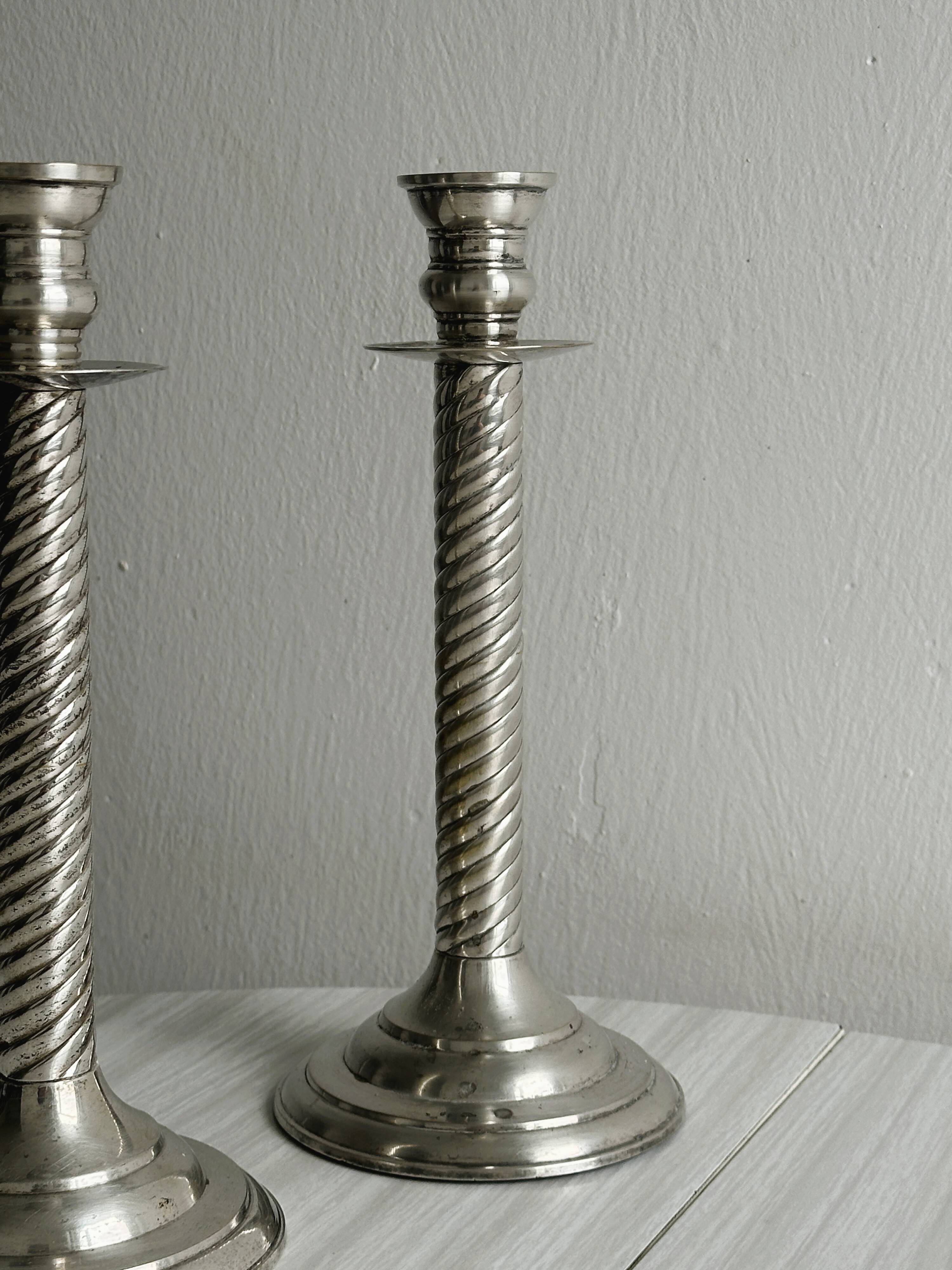 Patinated silver-plated metal candlesticks