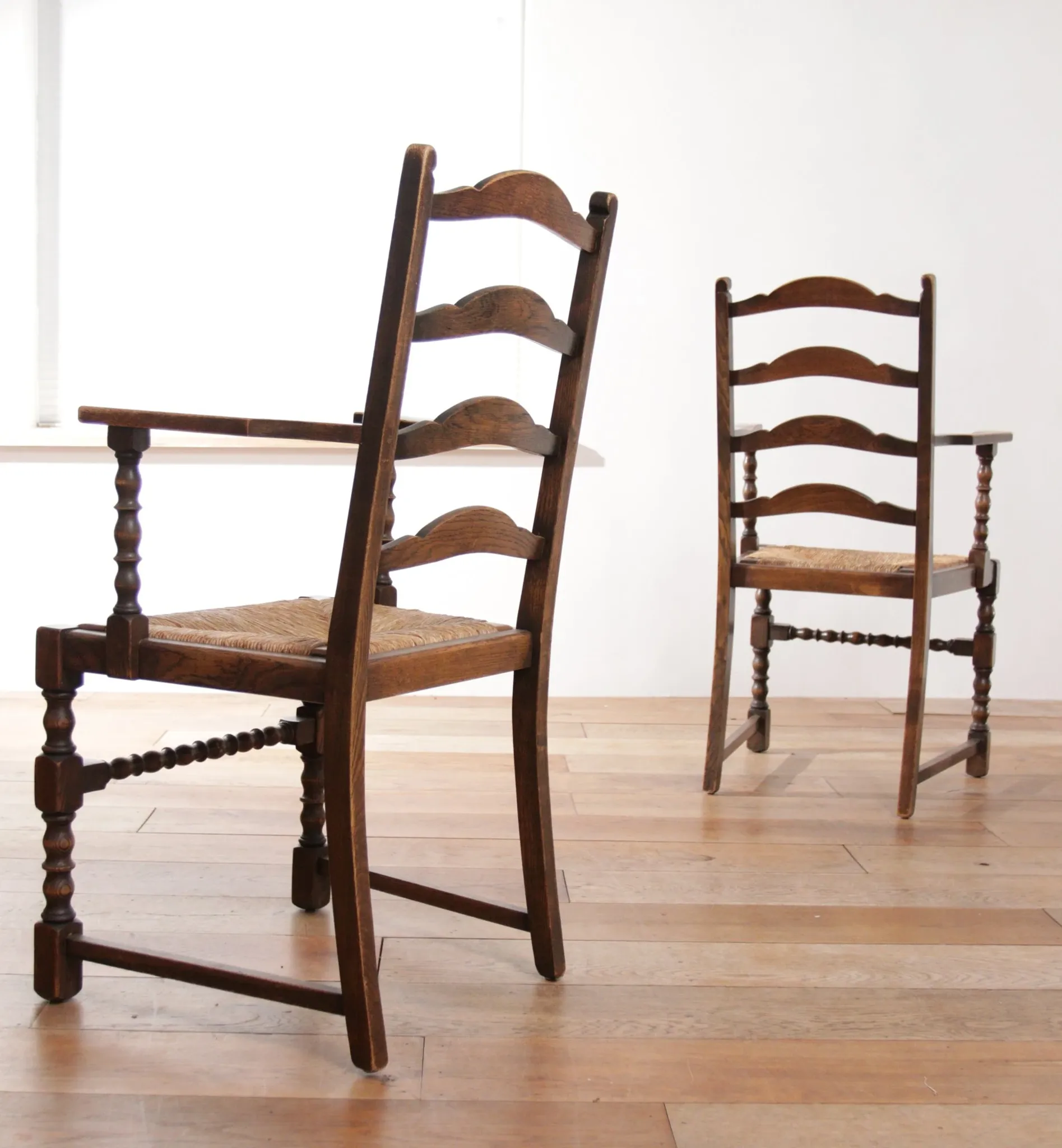 Pair of English oak armchairs with ladder back and rush seats