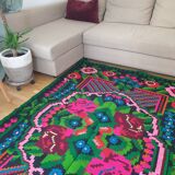 Handwoven colorful Romanian carpet, green and black background with gorgeous colorful flowers