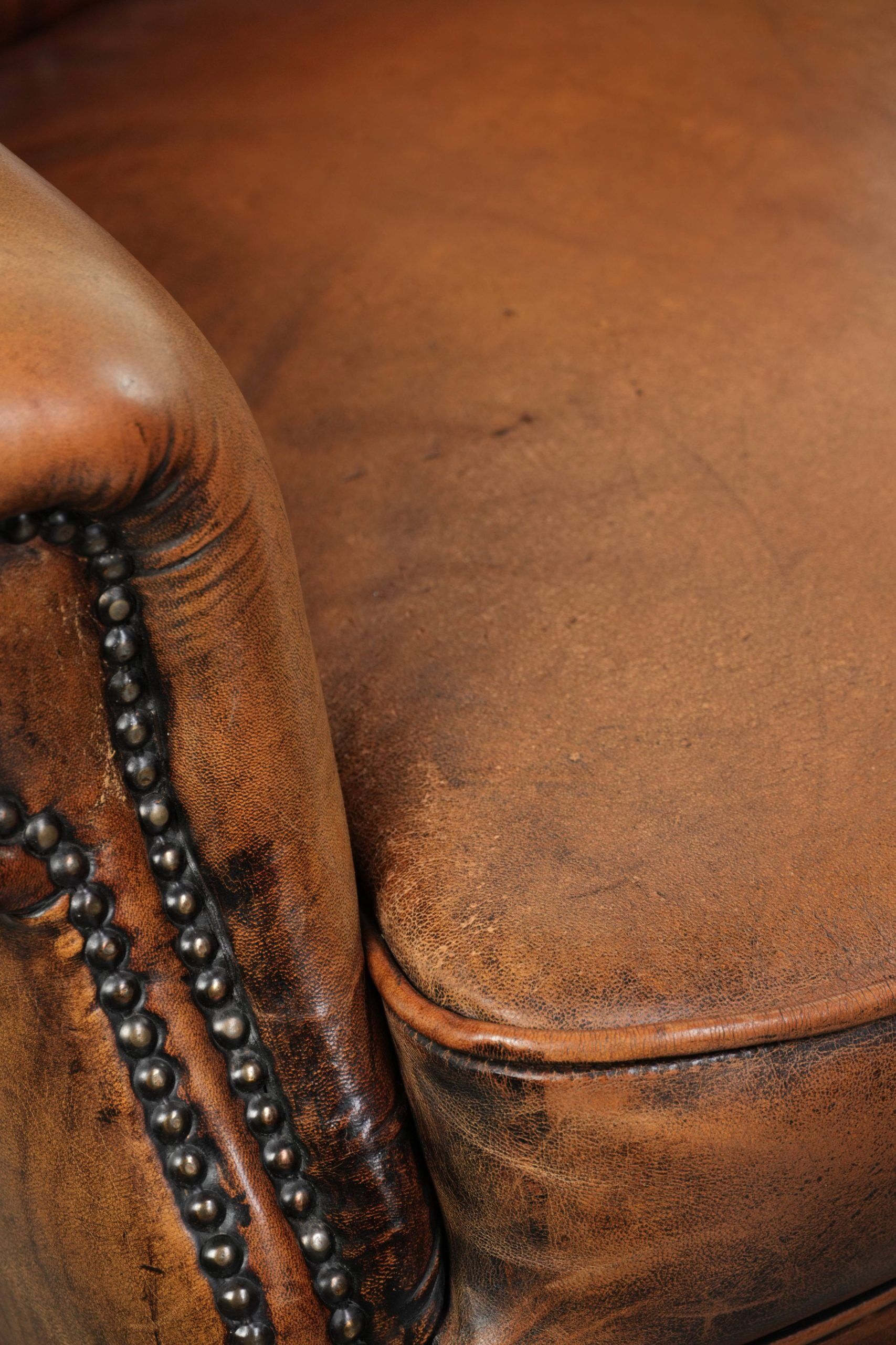 Wingback armchair made of sheepskin leather finished with decorative nails