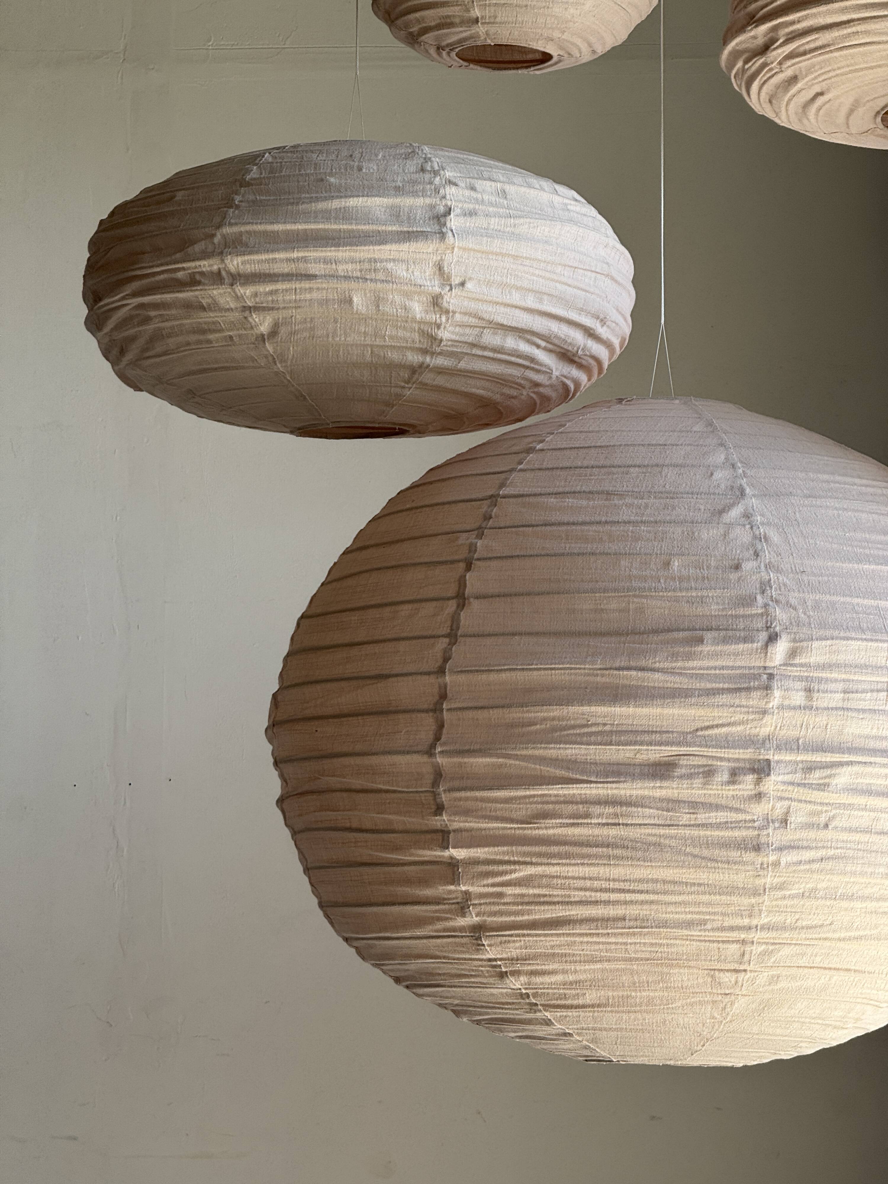 Average suspension in natural rattan and linen, Japanese-style, flattened oval in pink.