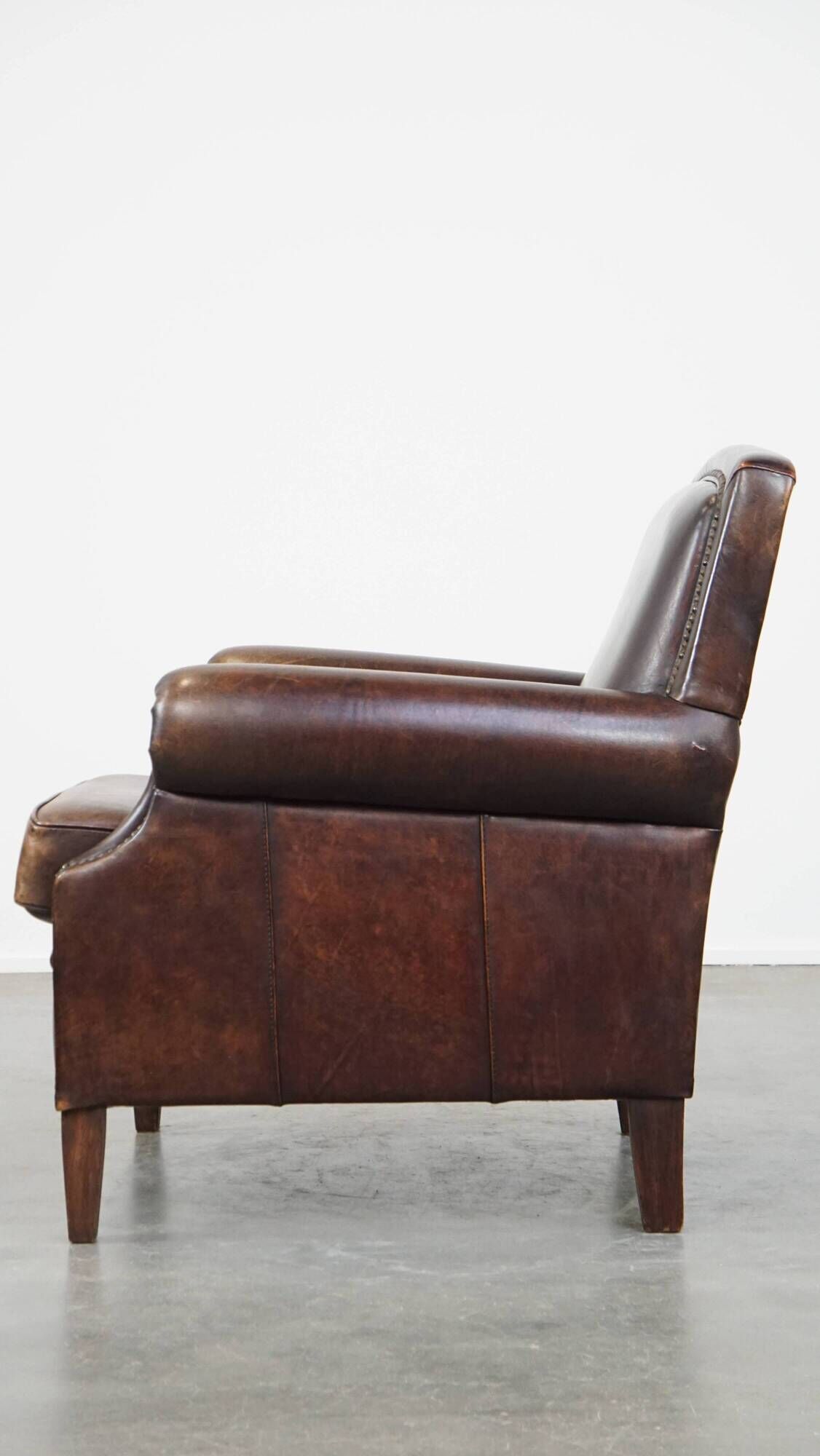 Dark brown sheepskin armchair finished with decorative nails