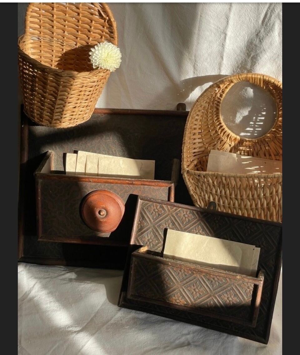 Hammered leather wall mail holder on wood.