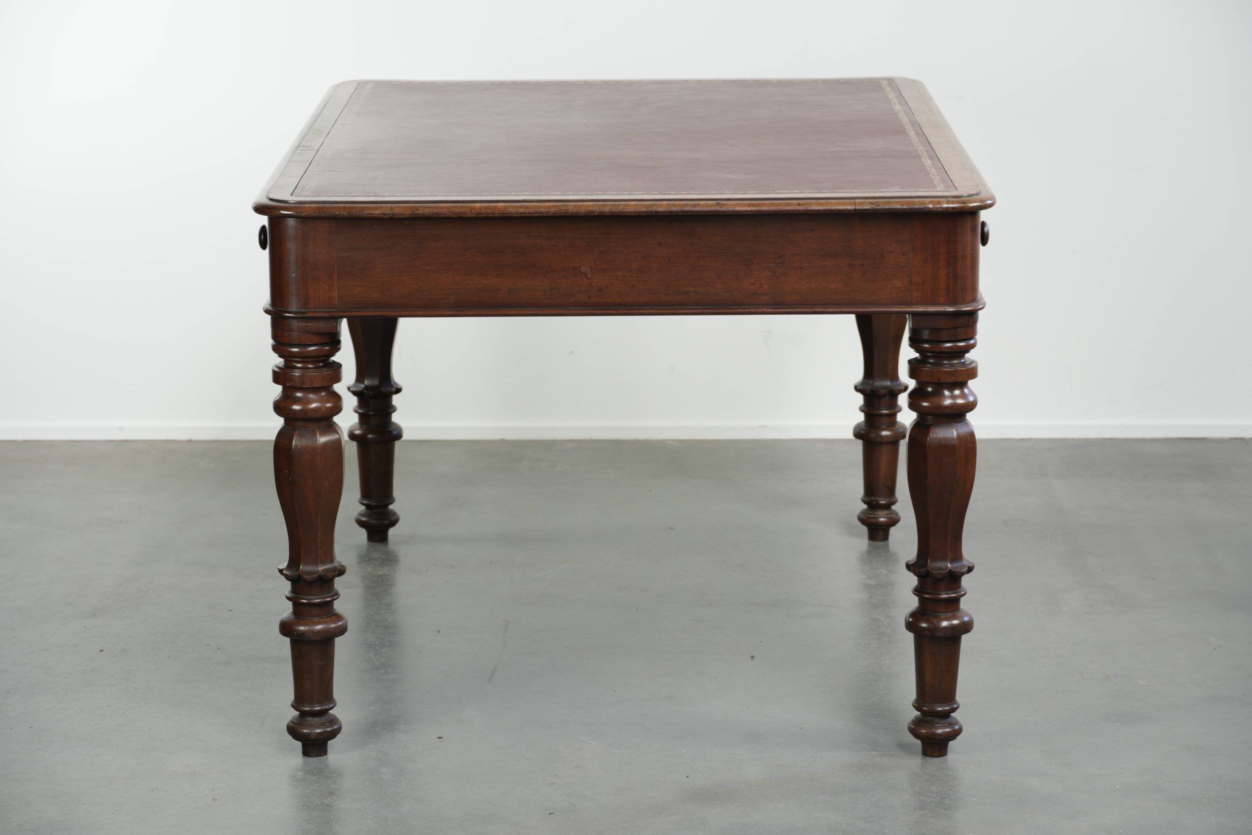 Antique English writing desk from the 19th century with a red leather top