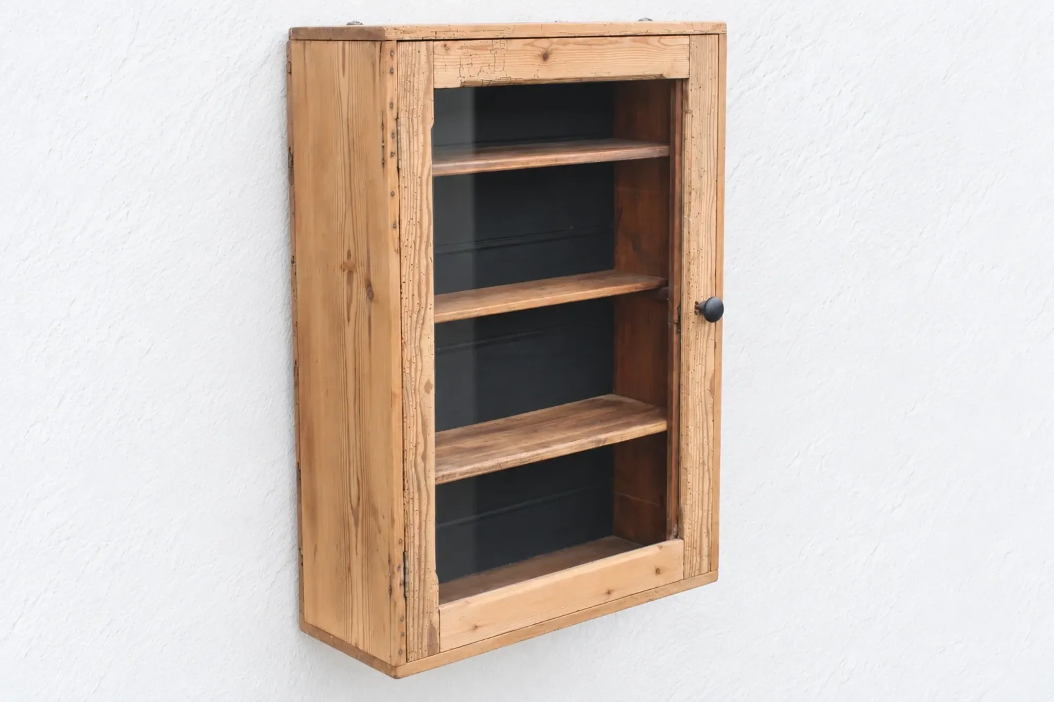 Antique wall display cabinet in natural wood and black – small glass-fronted collector's piece.