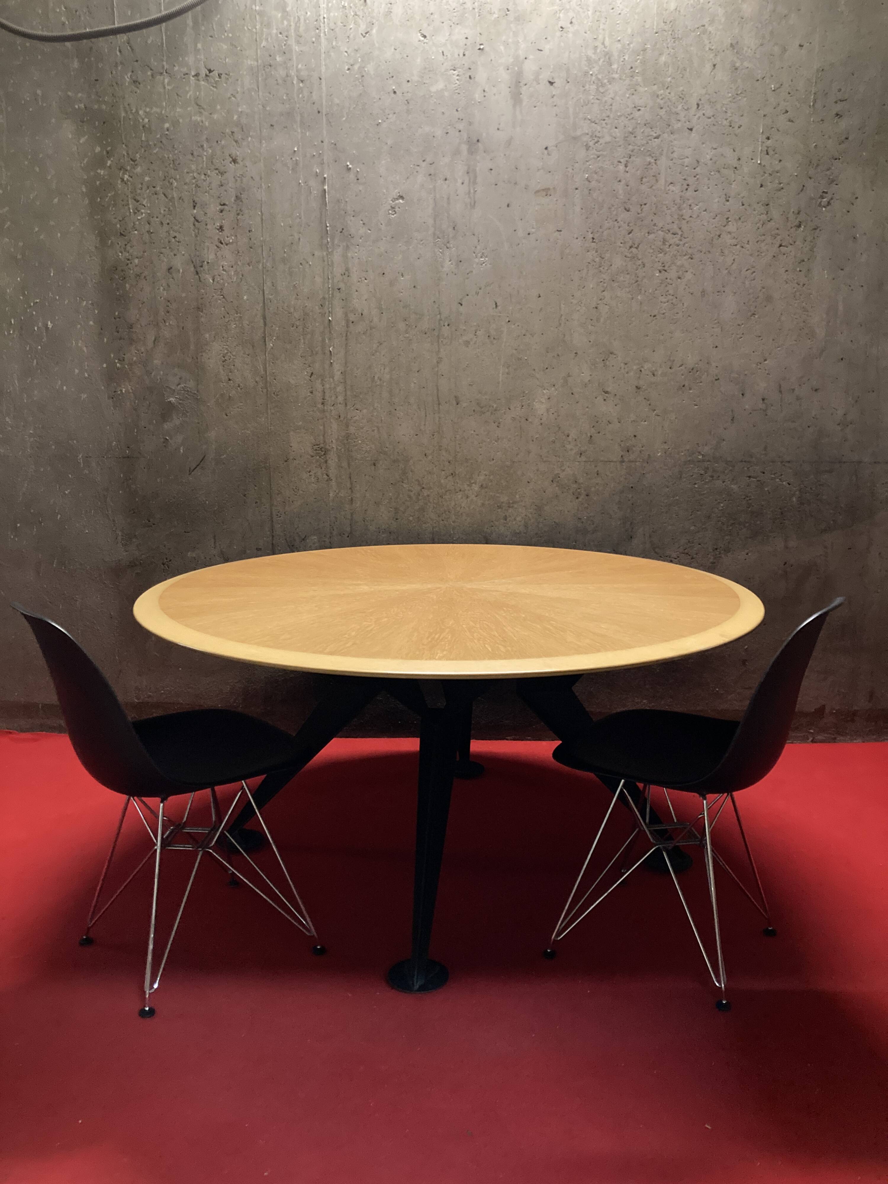 Round wooden and metal quadripod dining table