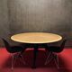 Round wooden and metal quadripod dining table