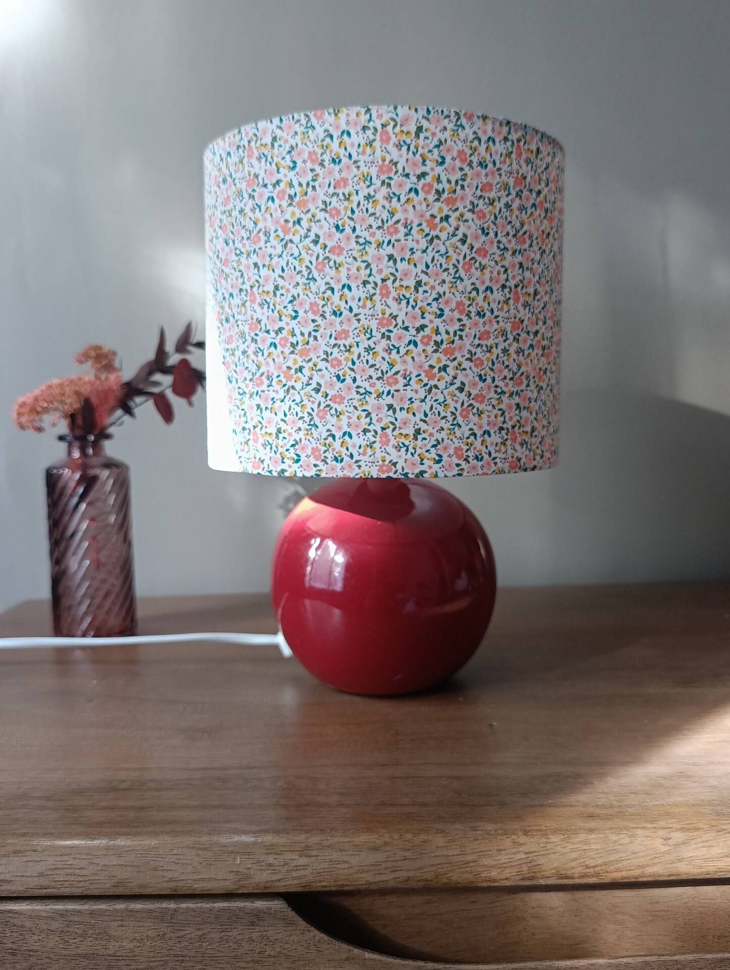 Red bedside lamp, liberty lampshade with small pink flowers.