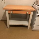 Vintage wooden kitchen table in orange and white with a drawer and low shelf.