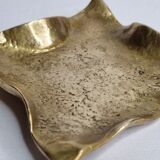 Empty pocket in polished brass representing a crumpled paper, signed CJ, 11.5 cm