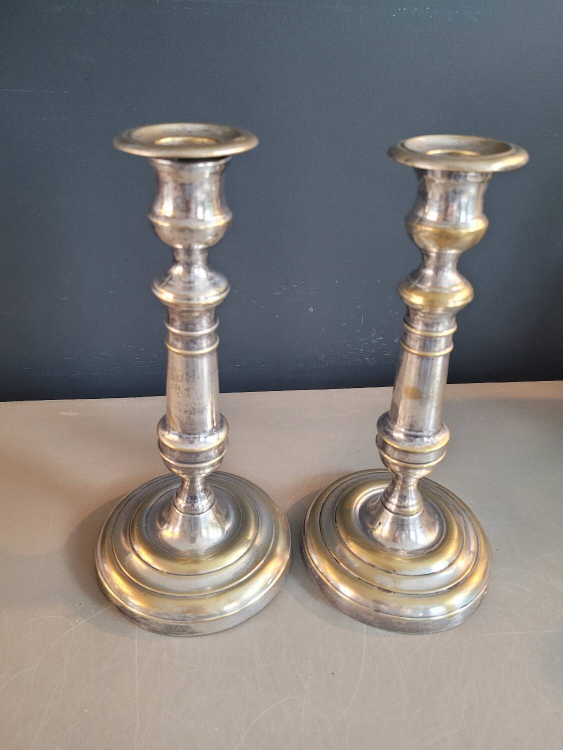 Paire de bougeoirs anciens en laiton argenté