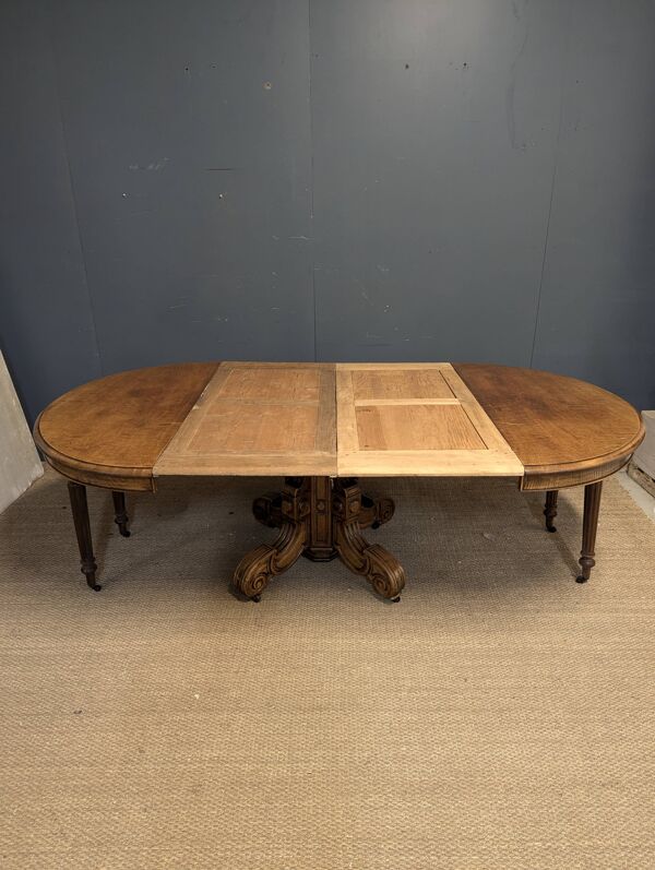 Guéridon, table extensible à pied central en noyer sculpté