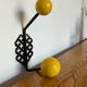 Perforated metal wall hook with yellow wooden balls, Matégot style.