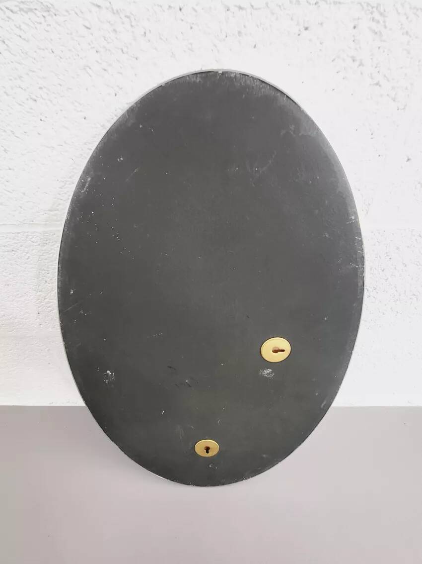 Oval mirror from the 1960s with a chrome frame.