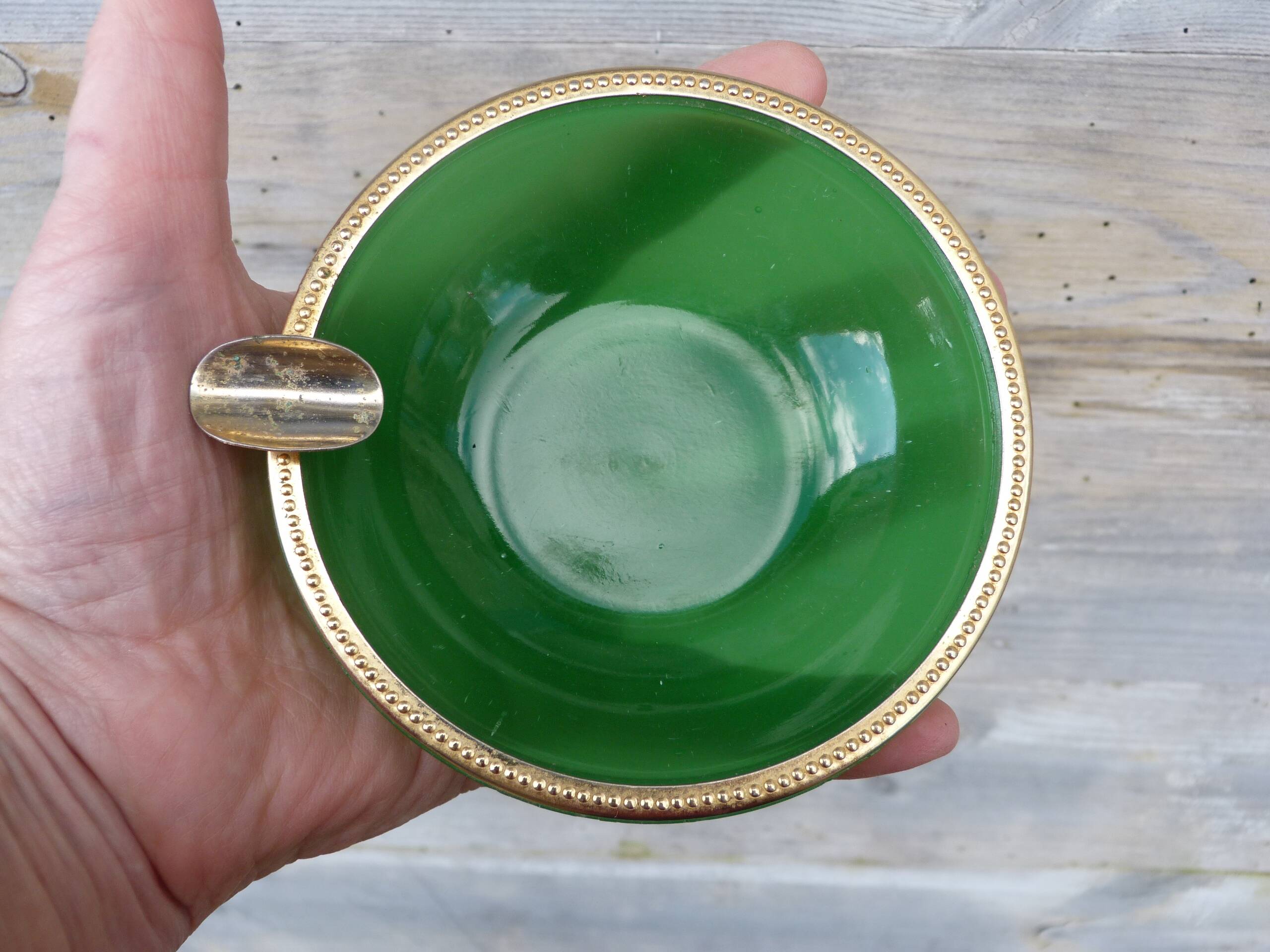 Green glass ashtray set in gold brass