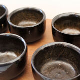 Set of 8 black ceramic cups signed