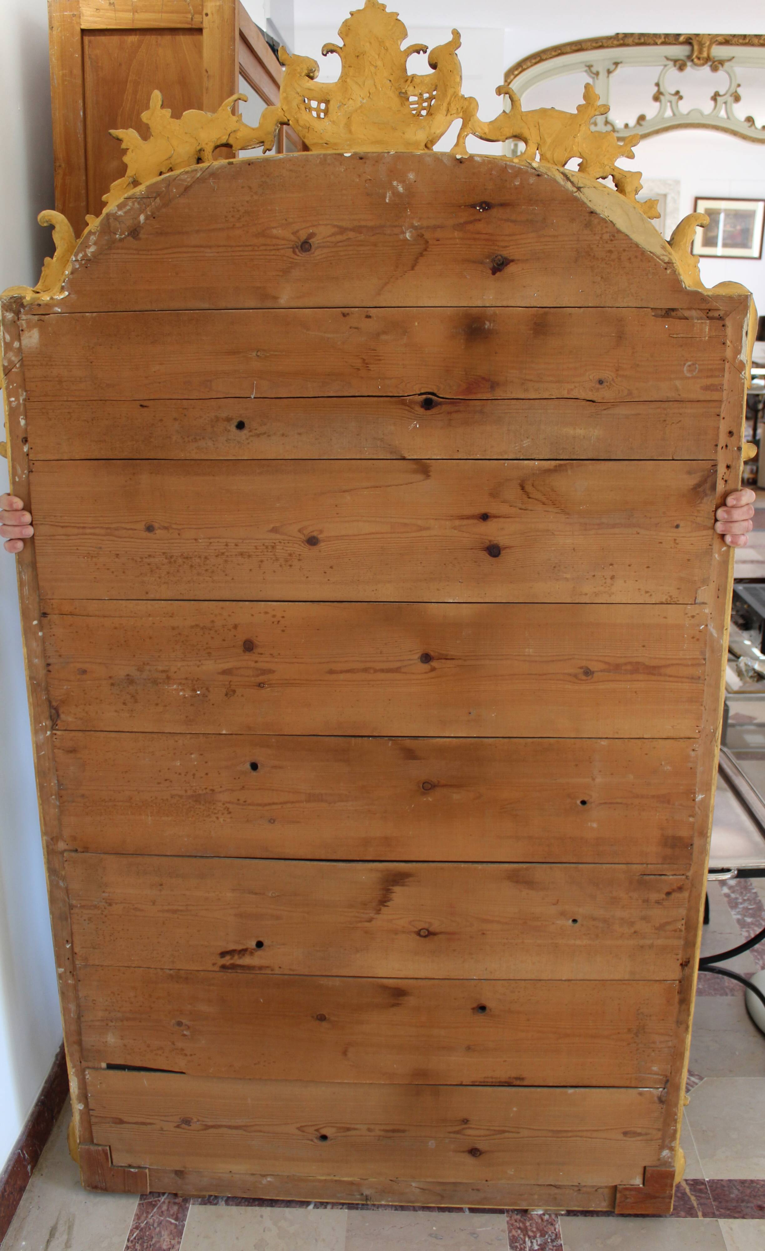 Large 19th-century wooden and gilt-studded mirror decorated with a cornucopia motif.