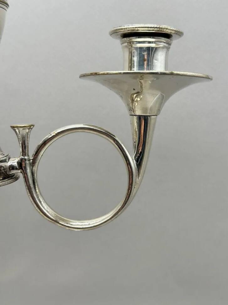 Pair of silver-plated metal candelabra decorated with hunting horns