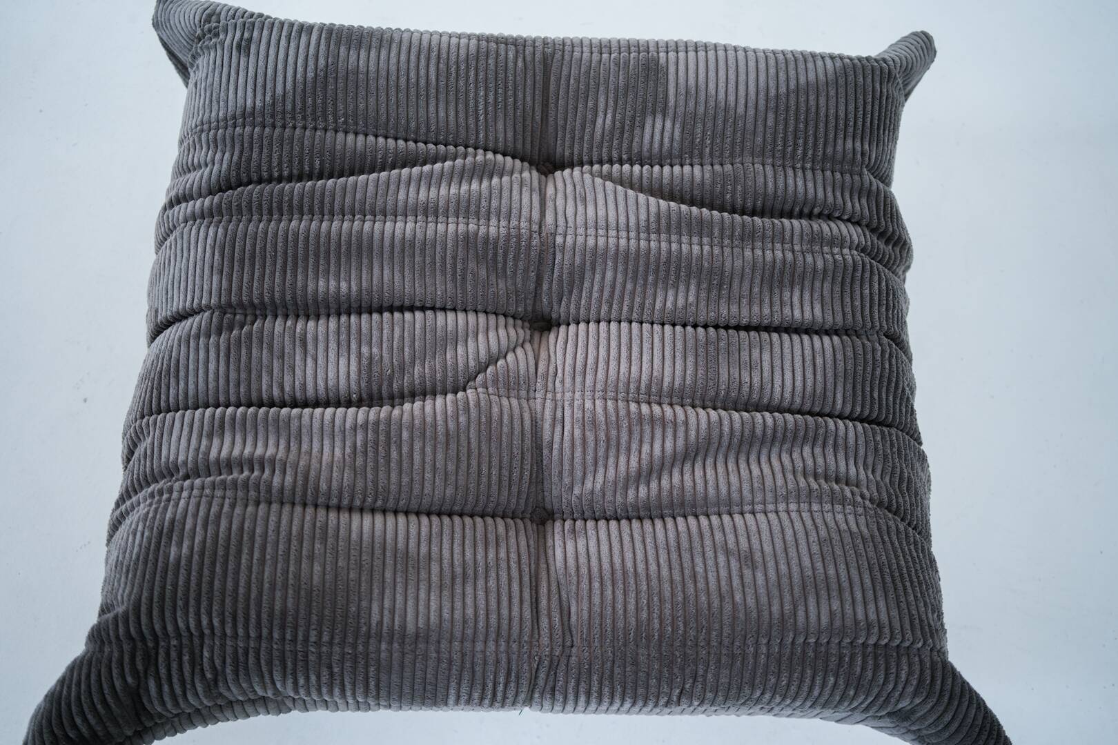 Ensemble de chaise et pouf Togo en velours côtelé marron.
