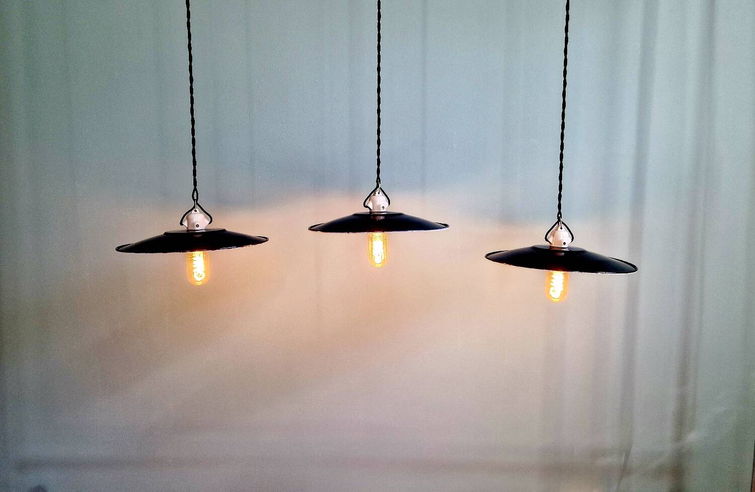 Three industrial suspensions in black enamelled sheet metal.