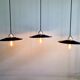 Three industrial suspensions in black enamelled sheet metal.