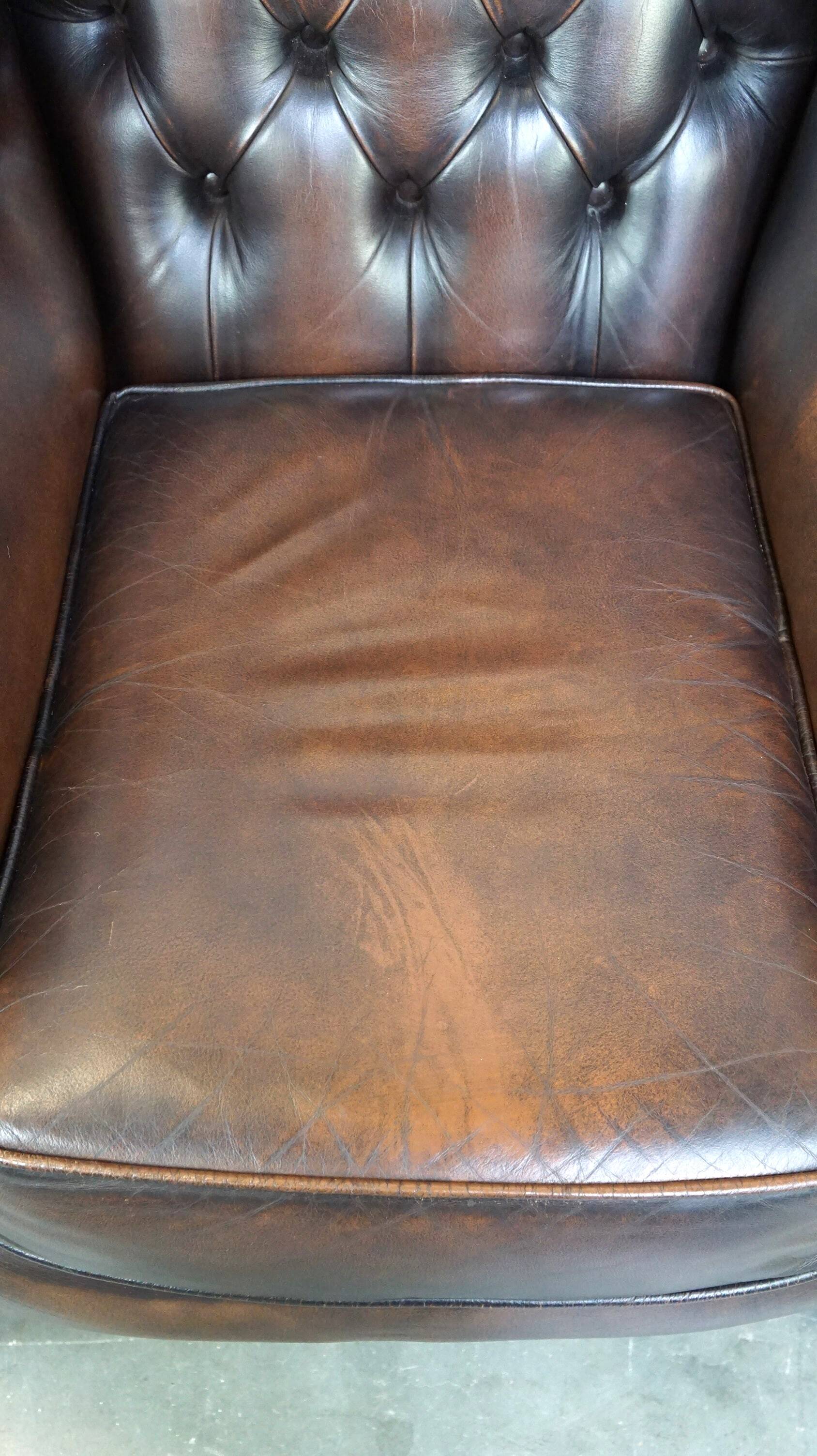 Chesterfield wing chair in dark brown leather with a luxurious appearance
