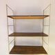 Golden wire shelf in metal with a wood effect.