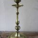 Brass candle holder with flowers and round shape.