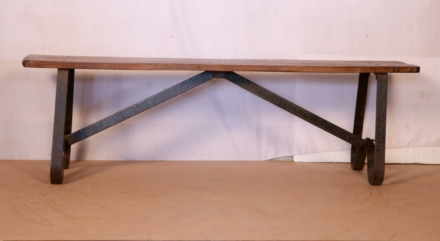 Old bench in Burmese teak with a wrought iron base.