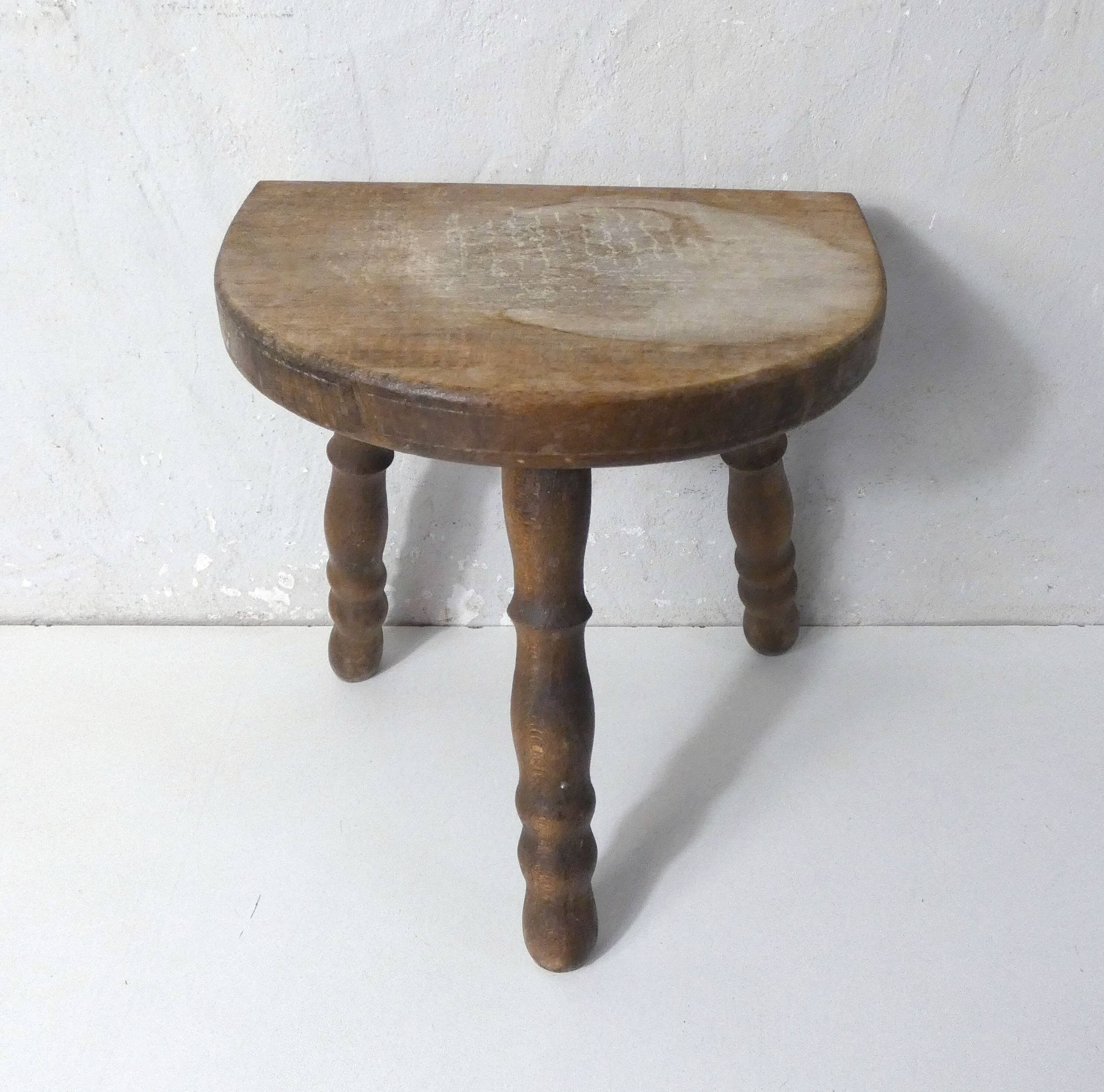Old milking bench tripod stool in solid wood