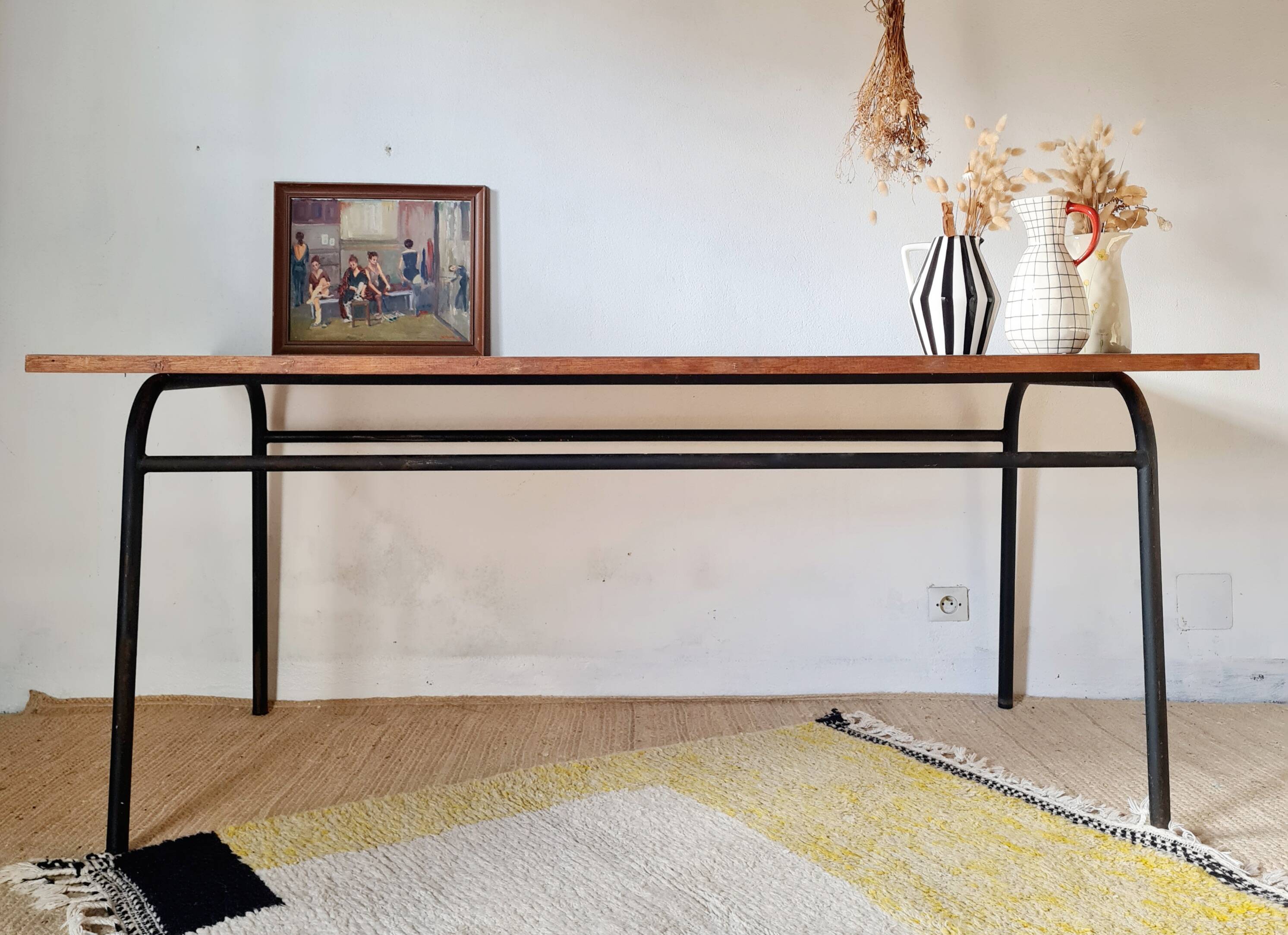 Table with tubular metal legs and wooden top.