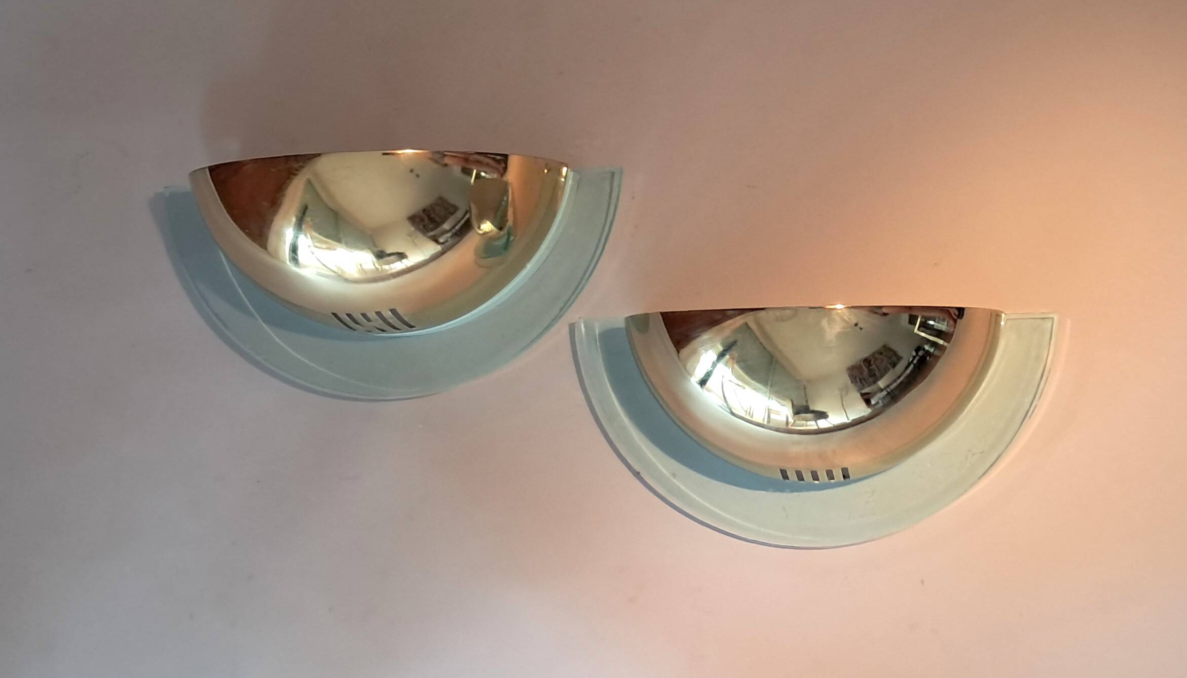 Pair of gold metal and plexiglass wall lights, circa 1980.