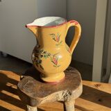 Large antique handmade ochre yellow jug with a pink flower pattern.