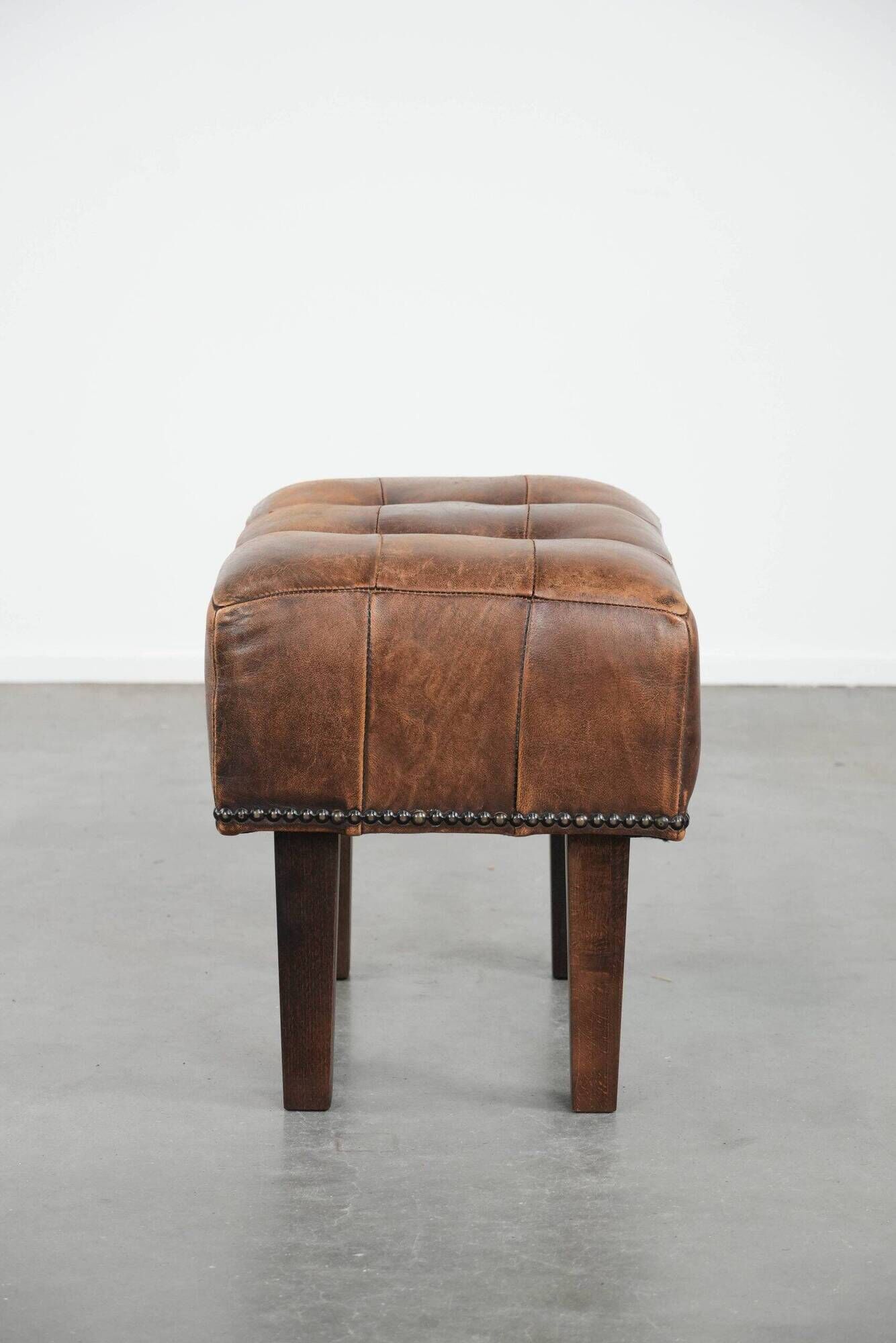 Beautiful sheepskin ottoman on high legs and beautiful warm colours