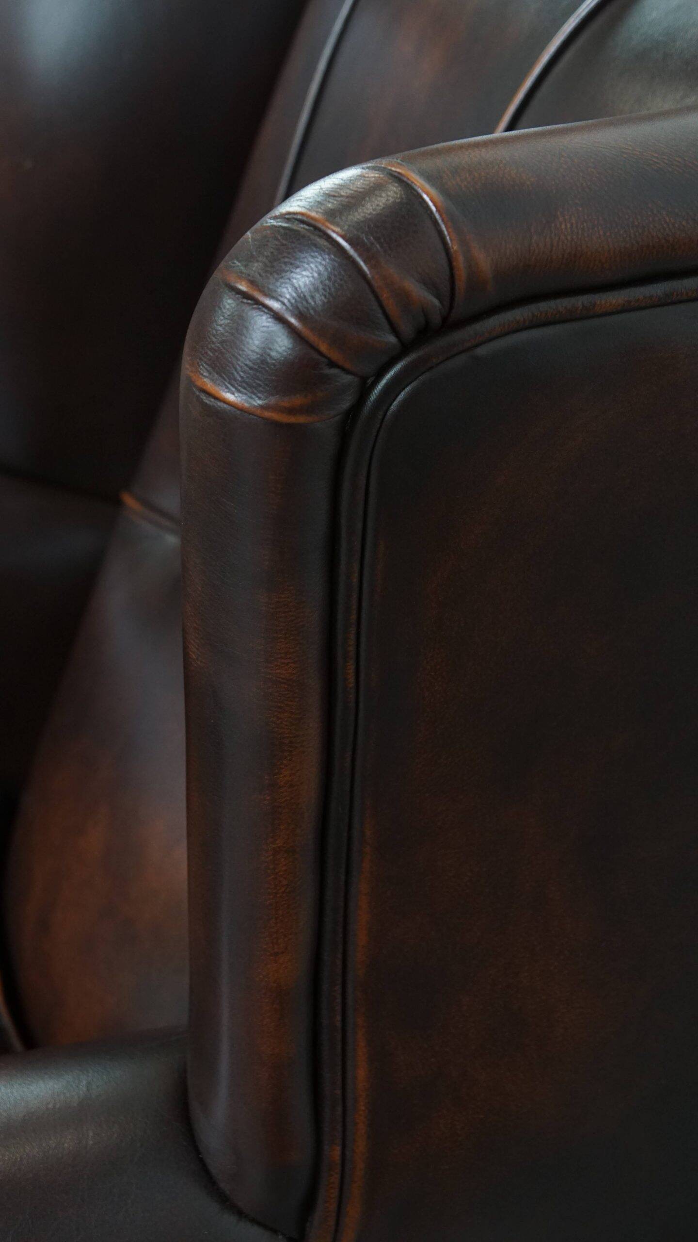 Comfortable wingback chair in English style made of cowhide leather