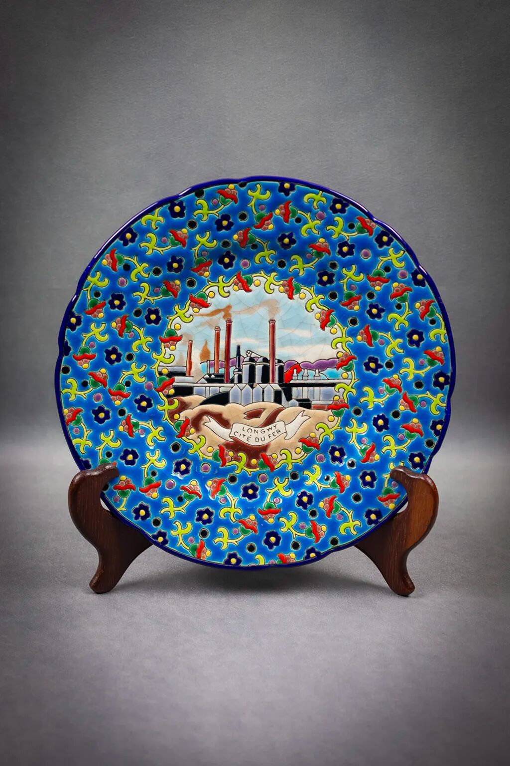 Longwy plate with polychrome enamels, decorated with the "City of Iron" motif.