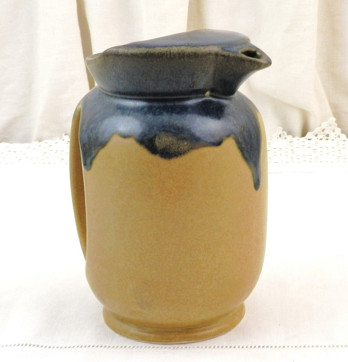 Vintage art deco water pitcher with drippy dark blue glaze.