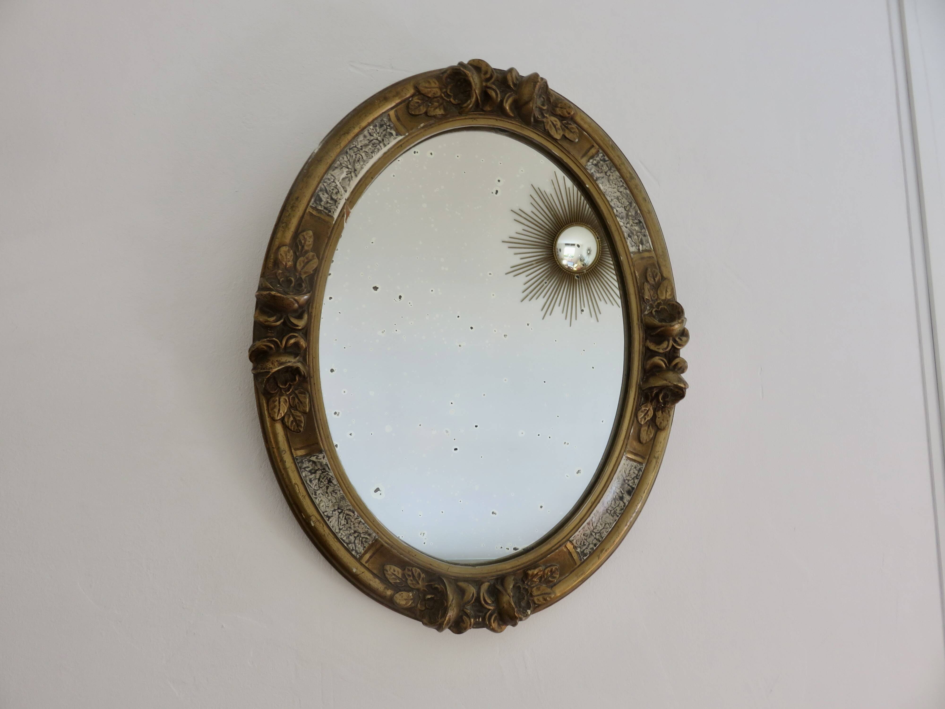 Oval wall mirror, golden floral pattern in stucco and wood, late 19th century