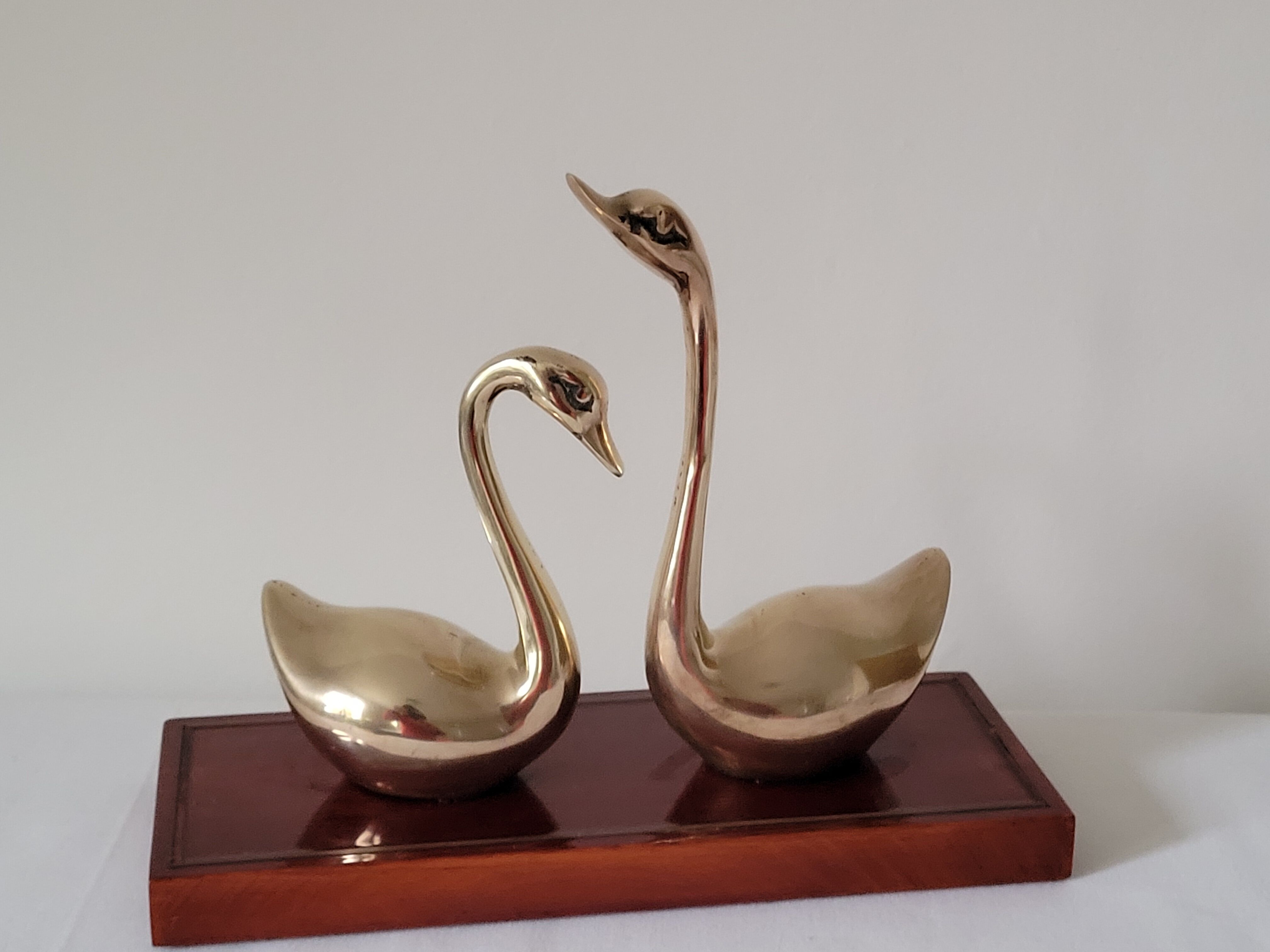 Duo of brass swans on base